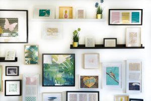 Parede com quadros decorativos de diferentes tamanhos e temáticas