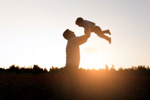 Pai e filho brincando no parque na hora por do sol